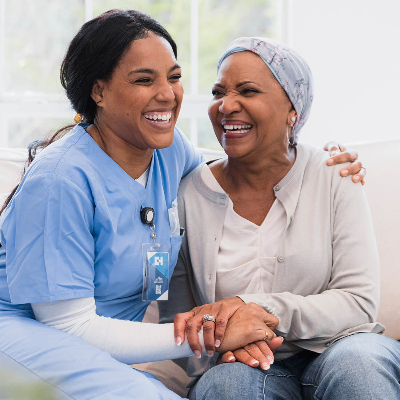 Nurse and older woman laughing together