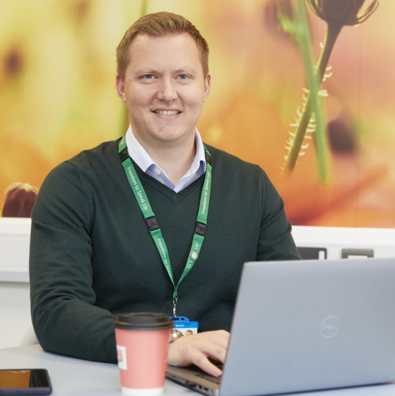 Man in green sweater working on laptop