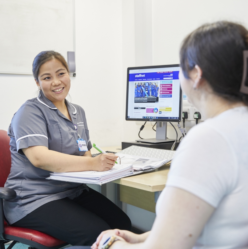 Healthcare worker at desk with patient