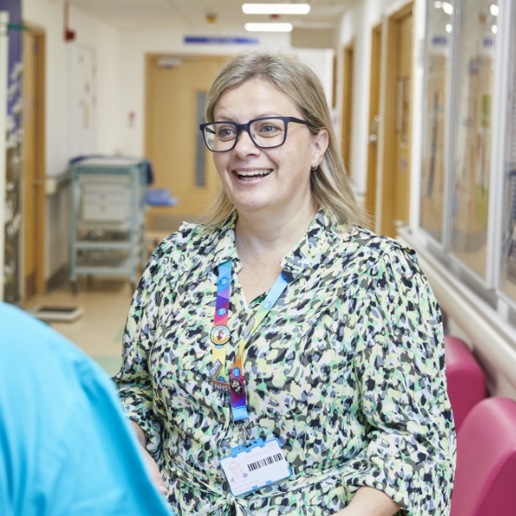 Smiling female healthcare worker with glasses in corridor