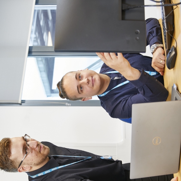 Two male professionals looking at a computer screen in office