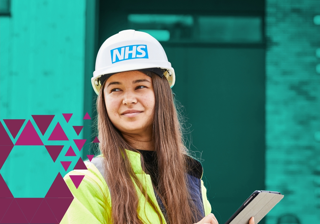 Woman in NHS helmet and vest holding a clipboard outside