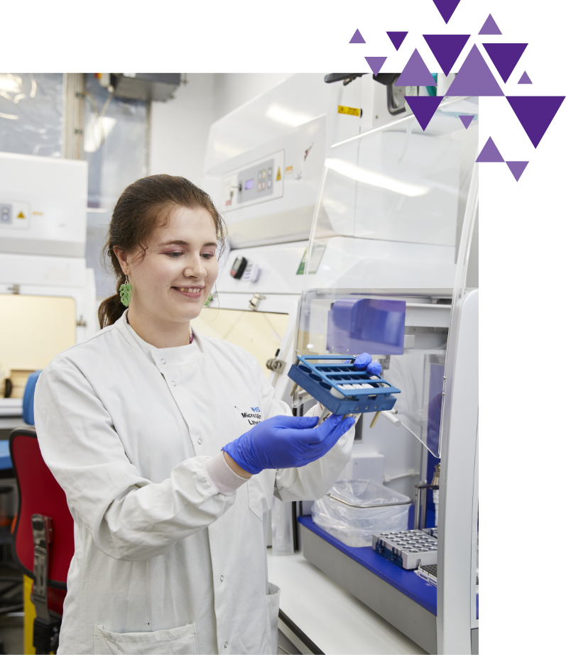Female scientist examining samples in a lab fume hood
