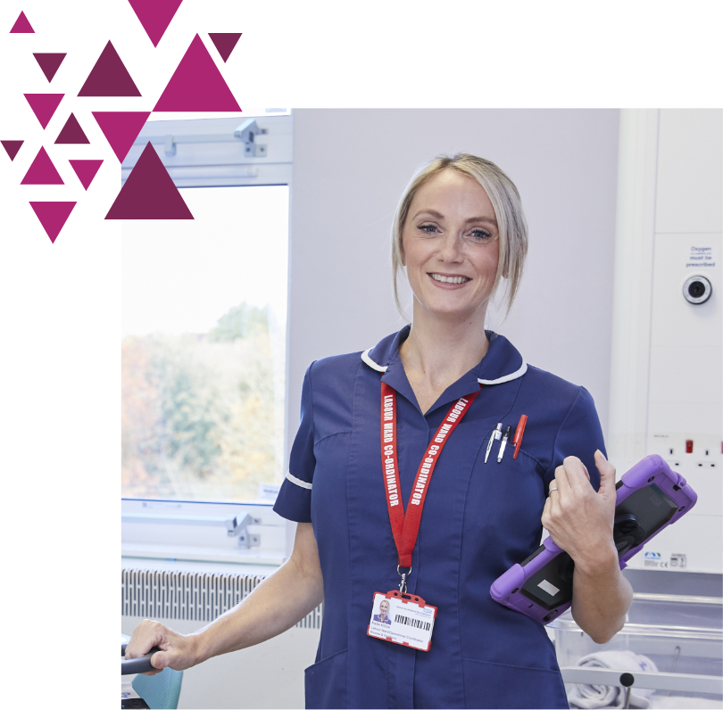 Nurse in blue uniform holding device near hospital window with autumn view