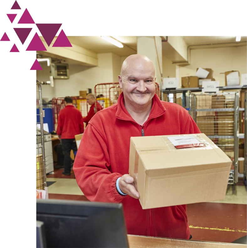 Man in red sweatshirt holding a box in a busy warehouse