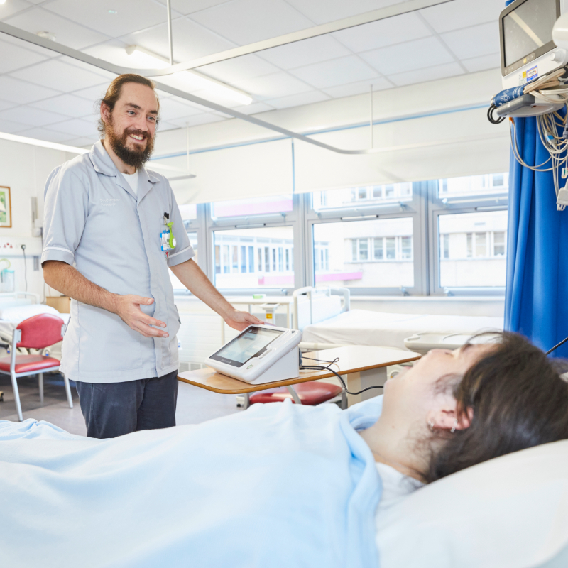 Male nurse talking to a patient in a hospital room