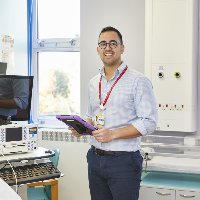 Smiling man in lab holding tablet
