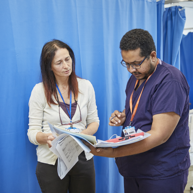 Two healthcare professionals reviewing a document
