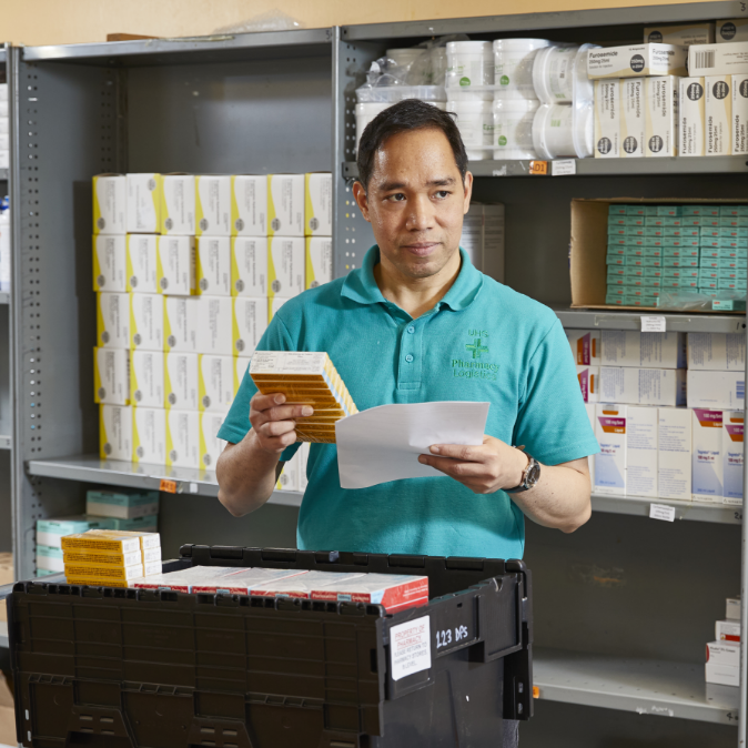 Male pharmacist scanning medication in pharmacy stock room          Ask ChatGPT