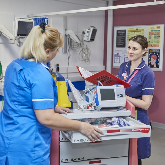 Two female medical professionals with a medical trolley