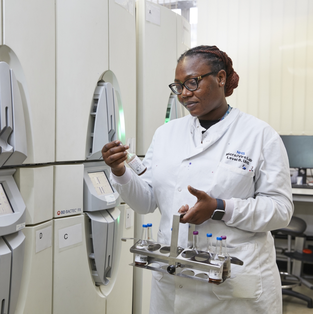 Female scientist using analytical machine in lab